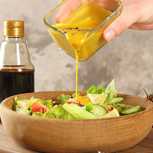 Salad dressing being poured over salad